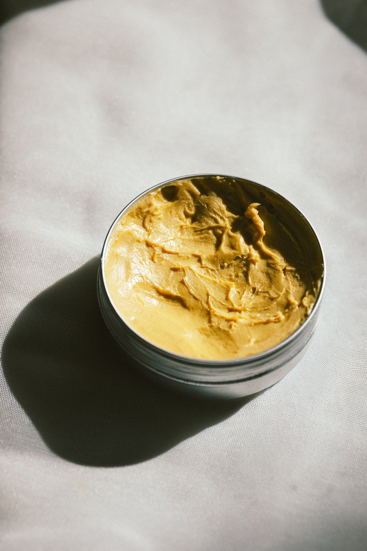 Open tin of Bless the Baby showing the soft grass-fed tallow baby balm