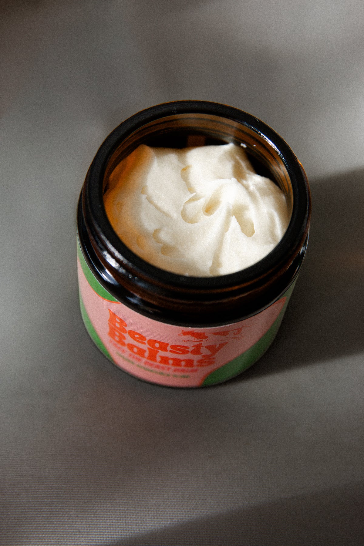 Open jar of Face the Beast showing the creamy texture of the tallow balm